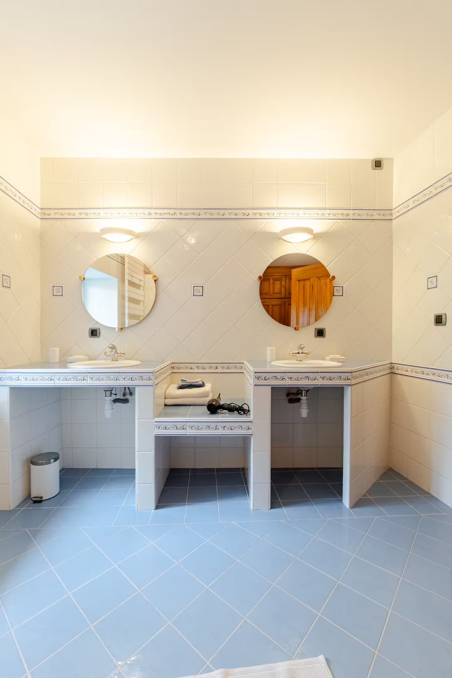 The bathroom, its two basins and round mirrors